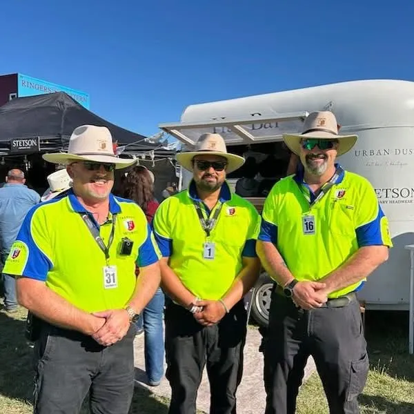 Guards in akubras working a rural sporting event