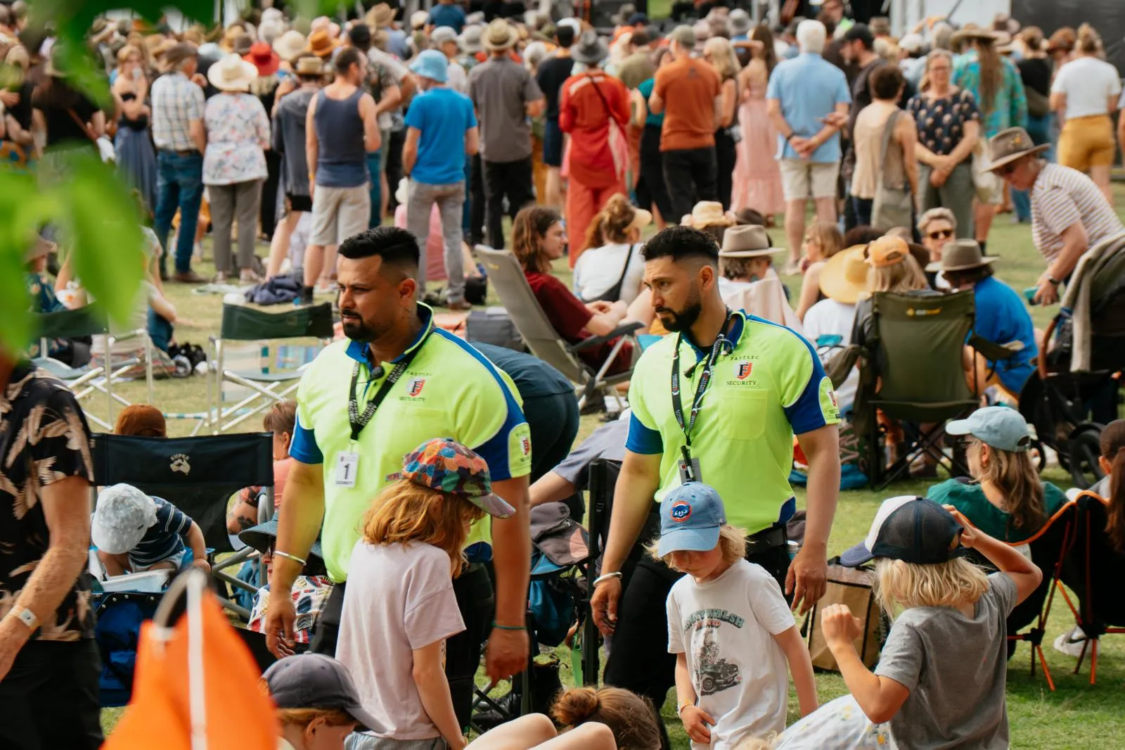 A uniformed guard standing among a seated crowd at a regional event